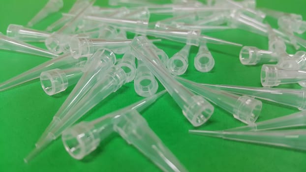 Close up view of micro litre tips on green floor sheet with empty holes. Reseach lab. tool for accurate measurement.