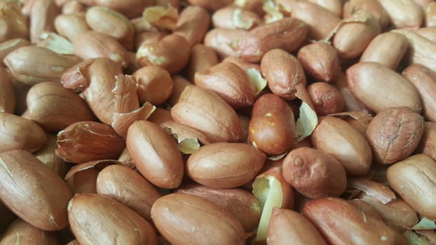 Closeup view of mixed, dried, roasted  peeled and unpeeled peanuts. A fruit for background text