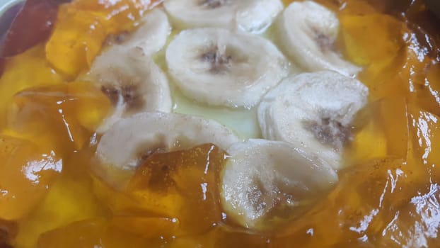 Creamy tasty sweet custard with banana pieces layered on surface. A close up tope view of home made custard, a dairy products for dessert after meal.