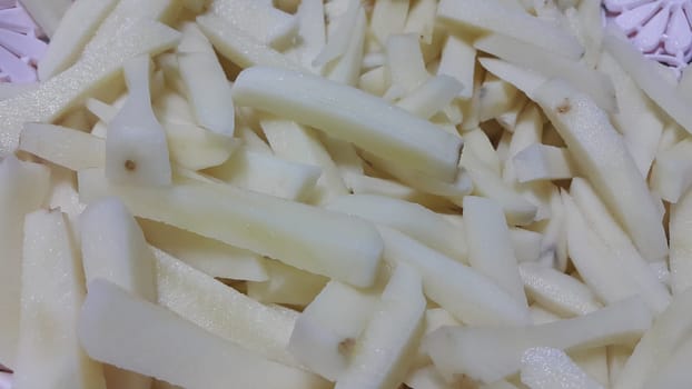 Closeup view of uncooked potato french fries or potato sticks with copy space for text