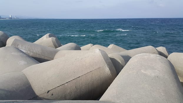 Close view of tetrapod stones on the sea shore to prevent coastal ersosion. Break water concrete tetrapods.