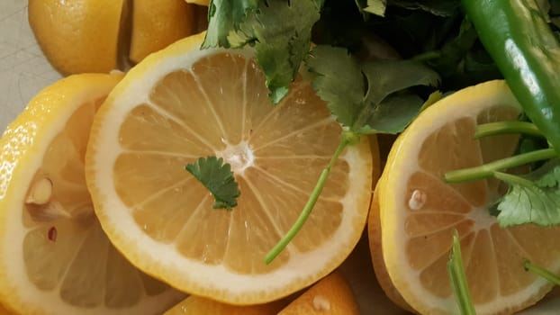 Top view of fresh lemon slices with green pepper cut into pieces for salad. Fruit background