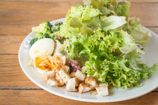 Homemade salad serving on wooden background, stock photo