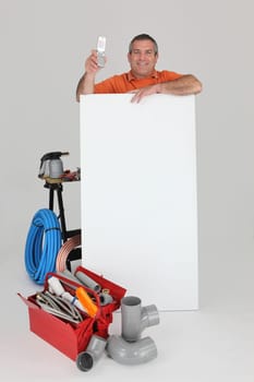 plumber behind wall showing phone