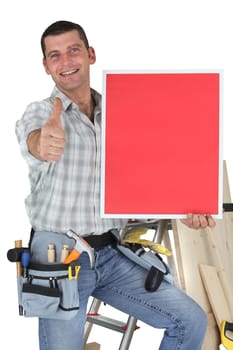 Carpenter stood by ladder giving the thumbs-up