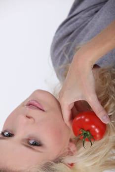 blonde woman posing with a tomato