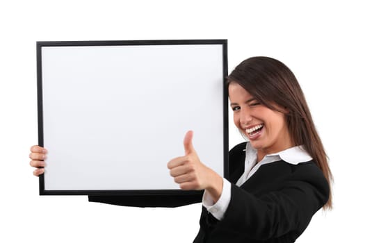 Enthusiastic woman giving the thumb's up and holding a whiteboard
