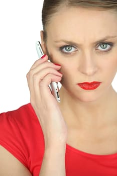 Annoyed woman in red using a cellphone