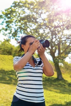 A black hair standing woman with a camera taking pictures
