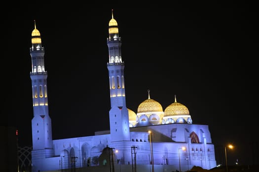 The illuminated Mohammed Al-Amin Mosque also called Bahwan Mosque near Muscat in Oman at night