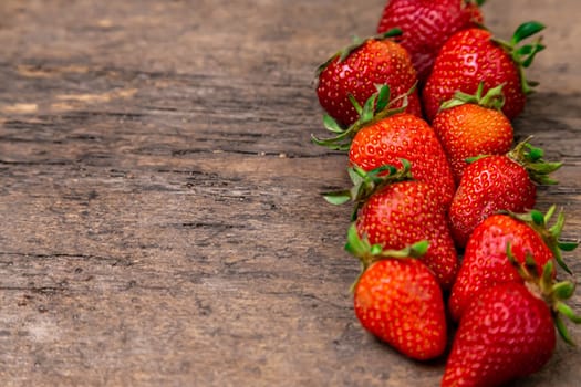 Tasty strawberry on a wooden table. It can be used as a background