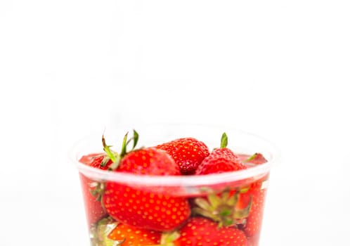 Delicious strawberries in glass bottle isolated on white background and copy space for text.