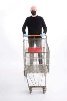 Man with mouth protection and hand gloves pushing a shopping cart, isolated on white background