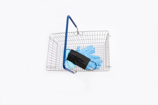 Shopping basket with hand gloves and mouth mask, isolated on white background