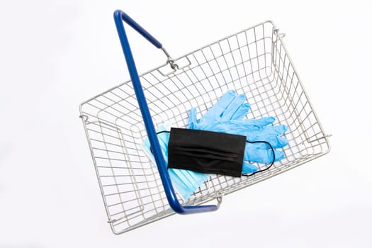 Shopping basket with mouth protection and hand gloves, top view, isolated on white background