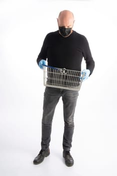 Man with mouth protection and hand gloves looking in his shopping basket, isolated on white background