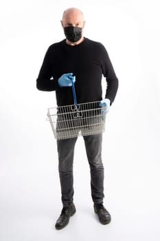 Man with mouth protection and hand gloves holding a  shopping basket, isolated on white background