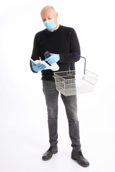 Man with mouth protection and hand gloves starting to clean a shopping cart, isolated on white background