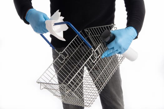 Shopping basket being cleaned by hands with gloves, isolated on white background