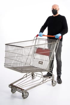Man with mouth protection and hand gloves pushing a shopping cart, isolated on white background