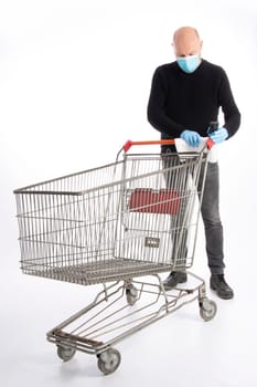 Man with mouth protection and hand gloves cleaning a shopping cart, isolated on white background