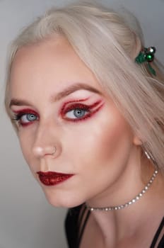 young blond woman with red glitter makeup