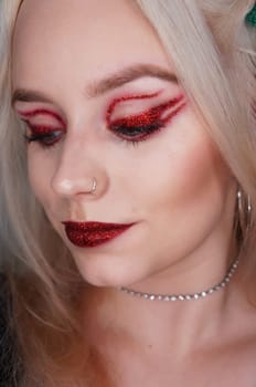 young blond woman with red glitter makeup