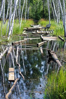 A boardwalk trail that has been flooded out and broken.