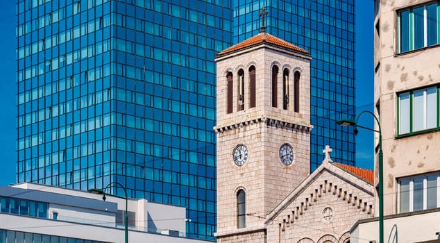 Old and new architecture in Bosnia and Herzegovina, Europe. Old and classical church building against new office building.