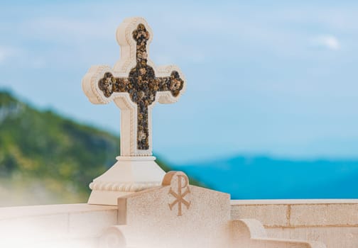 Cross in Monastery Ostrog of the Serbian Orthodox Church against blue sky and mountain. Montenegro travel, Europe.