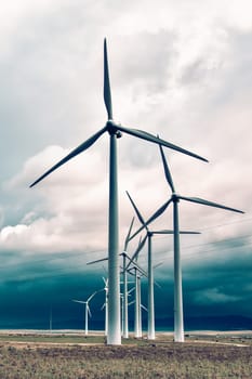 Wind turbines generating electricity in a stormy weather.