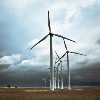 Wind turbines generating electricity in a stormy weather.