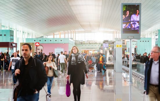 Barcelona, Spain, April 2019: people walking along the international departures corridor of El Prat airport in Barcelona, Spain