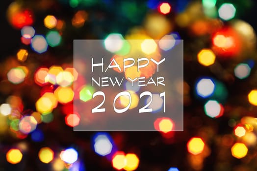 Happy New Year 2021 greeting card, blurred background of the twinkling lights of the Christmas tree. Greeting card background.