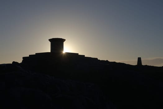 5 - Sunrise silhouette of the diamond jubilee toposcope at the summit of the malvern hills, the worcestershire beacon. Clear sky and sun star flare