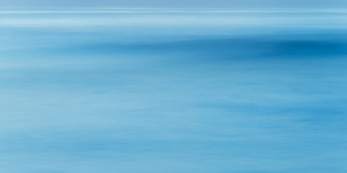 Long exposure of sea water and wave, full frame blue abstract background, shot at blue hour
