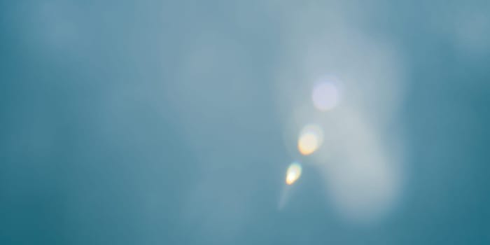 Abstract blue bokeh background with real lens flare