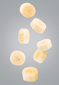 Flying exotic fruits. Seven peeled pieces of falling banana isolated on ultimate grey background with clipping path as package design element and advertising. Full depth of field.