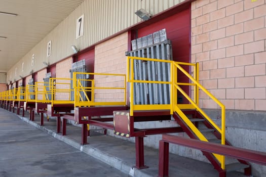 Truck loading docks at commercial building. Overhead door, dock leveler, and dock seals