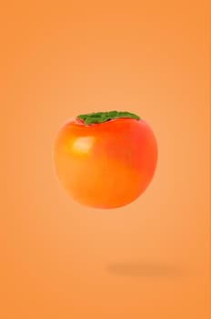 Minimal fruit concept. One whole persimmon fruit on bright orange background with shadow. Design element. Full depth of field.