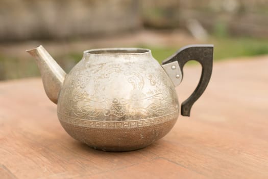 an old metal teapot without a lid.