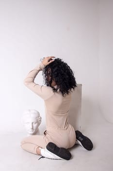 Fitness woman poses sitting, showing buttocks.