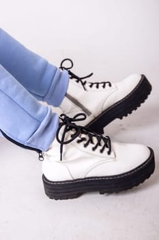 Female sneakers. White female shoes on feet.