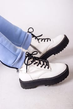 Female sneakers. White female shoes on feet.