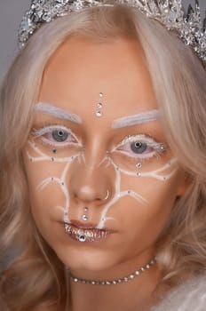 young blond woman with glitter makeup and crown