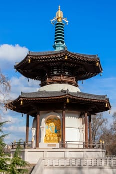 The Peace Pagoda in Battersea Park London England with gilded bronze gold Buddha statues which is a popular travel destination tourist attraction landmark of the city, stock photo image