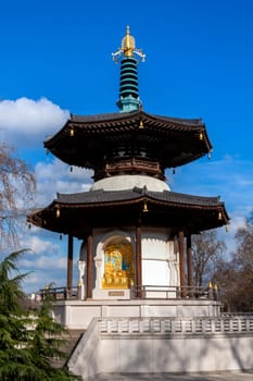 The Peace Pagoda in Battersea Park London England with gilded bronze gold Buddha statues which is a popular travel destination tourist attraction landmark of the city, stock photo image