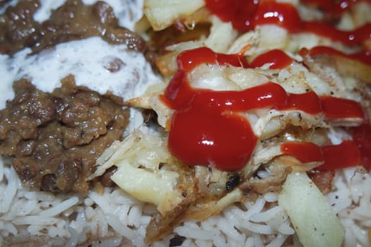 Delicious traditional dish of rice with potato fries and cereals with red ketchup. Food background with copy space for text and advertisements.