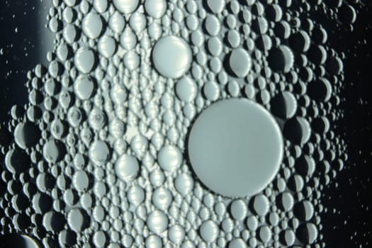 abstract macro background of oil circles floating over water surface . Macro closeup view of bubbles on water . oil bubbles in the water macro photographic background