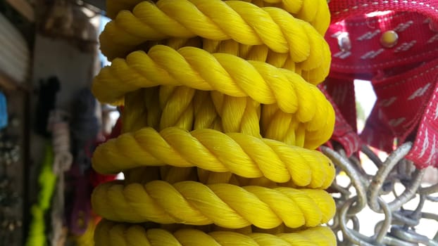 Closeup of bright color braided plastic ropes. Hanks or coil of bright colored plastic rope interwoven which are used for climbing and tightening materials.